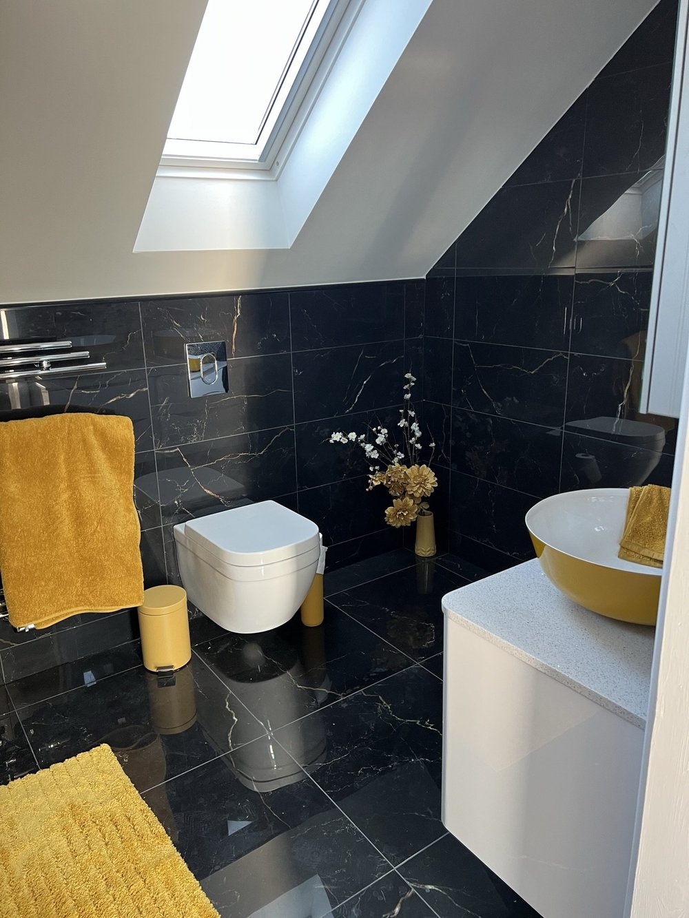 Bathroom with black marble tiles, skylight and yellow basin in Grays, Essex