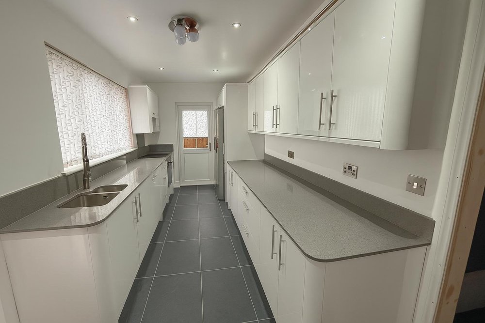 Fitted kitchen with white cabinets and grey countertops in Tilbury
